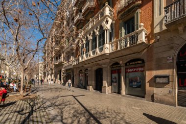 Barselona, İspanya - 5 Mart 2019. Barcelona 'da Passeig de Sant Joan' da tarihi binalar, balkonlar ve yayalar için ağaçla kaplı kaldırımları olan güneşli bir sokak.