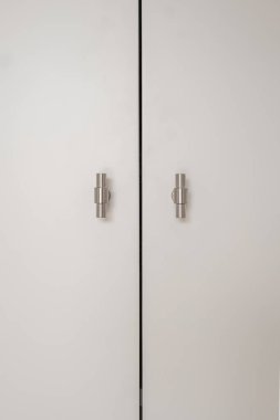 Parlak metalik saplı, simetriyi vurgulayan temiz ve basit bir gardırop tasarımı.