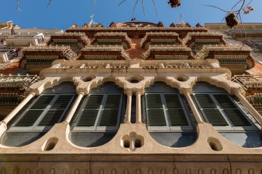 Dekoratif unsurları, balkonları ve eşsiz pencereleri olan tarihi Barselona binasının detaylı bir görüntüsü