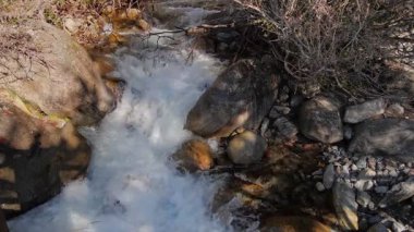 Güzel ve huzurlu bir dağ deresi manzarası, berrak suların yumuşak kayaların üzerinde zarafetle aktığı.
