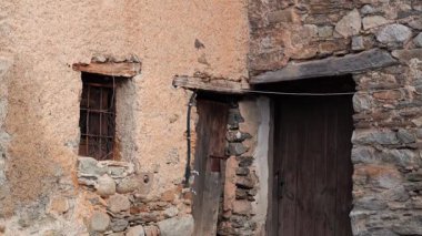 Köhne ahşap kapılar, küçük bir pencere, somut bir cazibe ve zengin bir geçmişi olan eski bir taş kulübe.