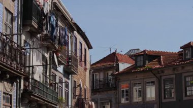 Porto şehir merkezinde sabah ışığında balkonları ve parlak çatıları olan eski konut binalarının uzak perspektifi