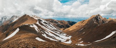 Pireneler 'in engebeli dağlarının nefes kesen manzarası dik yamaçlar, eriyen kar ve ağır bulutların altındaki uzak tepeler..