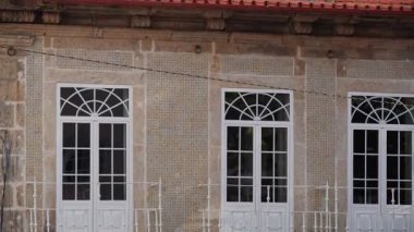 Taş ve mavi dekoratif duvar desenli eski bir cephede turuncu seramik fayansların çatı detayları