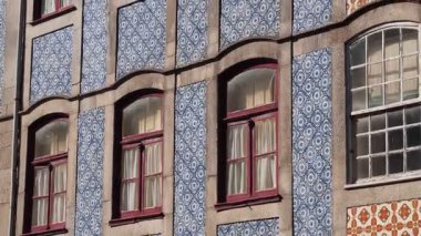 Geleneksel Portekiz binası duvarı yuvarlak pencereli ve kırmızı çerçeveli tekrarlanan mavi azulejo fayanslarını gösteriyor
