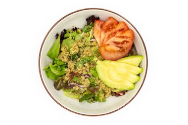 Sağlıklı kinoa salatası, yeşil domates ve avokado renkli taze malzemelerin altını çizerek servis edilir.
