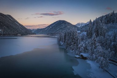 Weissensee Doğa Parkı 'nın güzel manzarası. Donmuş Weissensee Gölü, Carinthia, Alpler, Avusturya. Ocak 2022 'de hava aracı ateşlendi. Gün batımı zamanı.