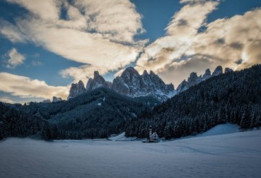 İtalya 'nın Val di Funes Villnosstal kentindeki Geisler veya Odle dolomites dağ zirvelerinin önündeki karakteristik kilisesi ile St. Magdalena veya Santa Maddalena. Ocak 2023. Uzun pozlama