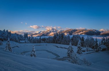 Avusturya, Carinthia 'daki Nassfeld kayak merkezindeki dağ zirvesinde gün batımında Alpenglow. Ocak 2022