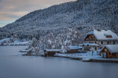 Techendorf gün batımında Weissensee Gölü, Carinthia, Avusturya karla kaplıydı. Ocak 2022