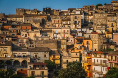 İtalya, Sicilya, Ragusa Bölgesi, Monterosso Almo. Haziran 2023. Birbirinin üstünde büyüyen şaşırtıcı küçük evler. Akşam vakti..