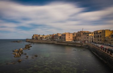 Siracusa, Ortigia Adası, Sicilya, İtalya. Isola di Ortigia, İtalya, Sicilya 'daki Syracuse şehrindeki Ortigia adasının kıyısında. Sahil şeridi kasabası Syracuse. Haziran 2023, uzun pozlama resmi