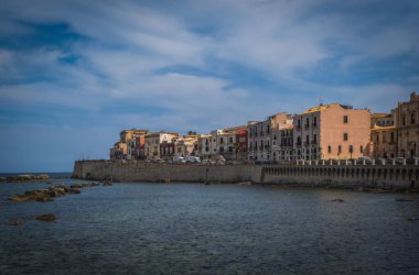 Siracusa, Ortigia Adası, Sicilya, İtalya. Isola di Ortigia, İtalya, Sicilya 'daki Syracuse şehrindeki Ortigia adasının kıyısında. Sahil kasabası Syracuse, Sicilya ve eski Ortigia adası. Haziran 2023