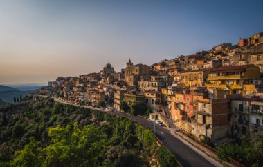 İtalya, Sicilya, Ragusa Bölgesi, Monterosso Almo. Haziran 2023. Birbirinin üstünde büyüyen şaşırtıcı küçük evler. Akşam vakti..