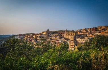 İtalya, Sicilya, Ragusa Bölgesi, Monterosso Almo. Haziran 2023. Birbirinin üstünde büyüyen şaşırtıcı küçük evler. Akşam vakti..