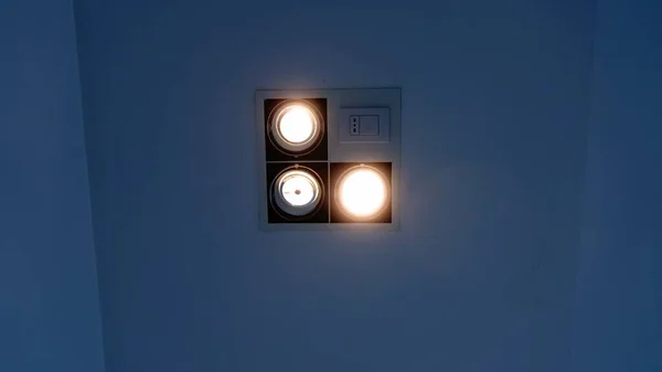 A small indoor lighting panel with three spotlights, switch and socket.