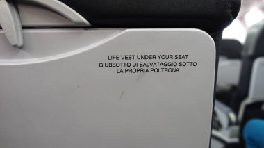 Uçak koltuğunun arkasında yazılı uyarılar var..