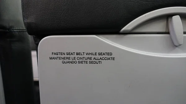 Tył Siedzenia Samolotu Pisemnymi Ostrzeżeniami — Zdjęcie stockowe