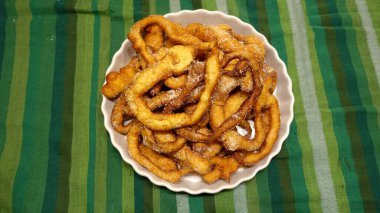 Bir tepsi kızarmış hamur yılanı ve şeker hazır. Geleneksel İtalyan Frittelle.