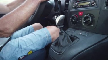 Manüel şanzımanı olan eski bir arabanın içi ve sürücüsü..