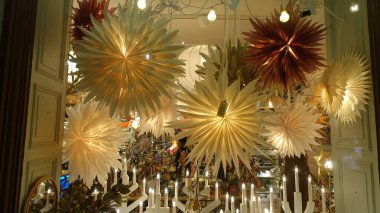 Stockholm, İsveç, 7 Aralık 2024. Yıldızlar, mumlar, doğum sahnesi ve Noel süslemeleri ile süslenmiş bir dükkan penceresi..