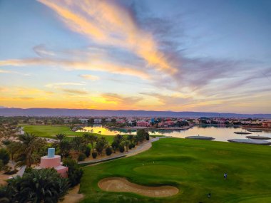 Green Field with the Colorful Sky at Sunset - Showing the amazing colors of the sky at the sunset