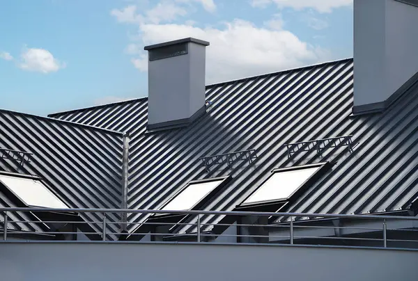 Dikişleri ve bağlayıcıları olan eski çatı paneli. İade eklemli klasik stil siyah metal panel. Kaburgalı, modern galvanize çelik çatı kaplaması. Falz çatısı. Bina kapatıyor.