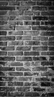 Eski tuğla duvardan yapılmış siyah beyaz bir manzara. Kırık tuğlalı ve soyulmuş alçılı eski duvar ustası dokusu. Çatı katı iç veya dış arka plan deseni. Kentsel, grunge, endüstriyel, soyut zemin