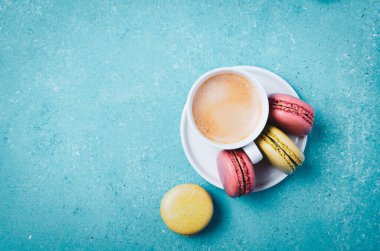 Bir fincan kahve ve makaron. Renkli turkuaz arkaplan.