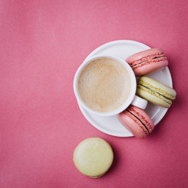 Bir fincan kahve ve makaron. Renkli pembe arkaplan.