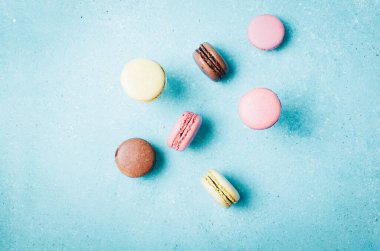 Macarons on turquoise background. Top view, copy space.