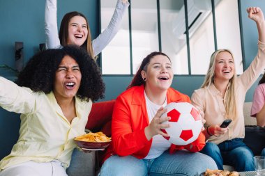 Bir grup genç kız, kadınların futbol maçı şampiyonasını izliyor.