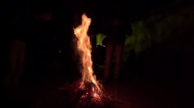 Gece vakti büyük bir yangın ve alev 4K videosu. Kış mevsiminde ateşi kullanarak kendini ısıtan bir adam. Kırsal bir bölgede 4K 'lık bir alan yanıyor ve yanıyor. Karanlık gece ateşi kutlaması.