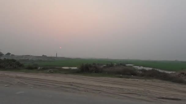美丽的日落美景在农村地区4K视频 黄昏时的乡间公路旅行录像 美丽的草地 和日落景色从一个移动的车辆 乡郊公路旅程4K段 — 图库视频影像