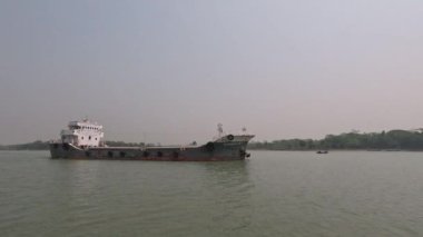 Nehirden geçen büyük bir gemi, manzaralı kırsal manzara 4K video. Kargo gemisi 4K görüntüleri taşıyor. Güzel nehir manzaralı, kargo gemisi ve mavi gökyüzü. Nehir ve geminin doğal manzarası..