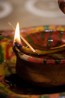 Hindu dekore edilmiş kil lamba ve bulanık bir arka plan. Özel durumlar için Hint ritüeli ve kültürel Diya. Madalyalı Hindu kil lambası. Geleneksel Hindu tapınması ve puja elementleri yakın çekim.