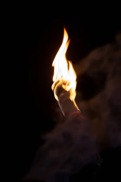 黑暗背景下的火把 一个木制火把 带有燃烧的火势特写镜头 夜间用火把着 一个木制的火炬近景与明亮的黄色火 火把上美丽的火焰 — 图库照片