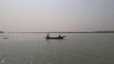 Nehirde yüzen ahşap bir teknenin güzel manzarası. Nehirde yelken açan bir denizci. Güzel kırsal yaşam ve nehir manzarası ve güneş ışınları için parlayan nehir suyu. Nehir ve gökyüzü.