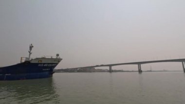 Nehrin yakınından geçen büyük bir tanker gemisi. Manzaralı nehir ve köprü manzaralı bir su kabı. Köprüsü olan kırsal su taşıma alanı. Kanaldan geçen bir tanker gemisi..