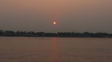 Nehir kıyısından güzel bir günbatımı videosu. Alacakaranlıkta, nehrin akışıyla gün batımının hızlandırılmış görüntüsü. Nehir, kırsal alan ve günbatımı olan güzel doğa görüntüleri. Nehir kıyısından alacakaranlık gün batımı.