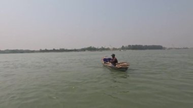 Barisal, Bangladeş - 5 Nisan 2023, Güneydoğu Asyalı balıkçılar küçük botlarla kırsal yaşam sürüyorlar. Küçük balıkçı teknesi ve oltayla balık yakalayan balıkçılar. Güzel nehir ve balıkçı görüntüleri.