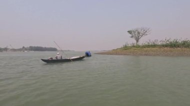 Barisal, Bangladeş - 5 Nisan 2023, Küçük balıkçı teknesi ve balıkçılar oltayla balık yakalıyorlar. Güneydoğu Asyalı balıkçılar küçük tekneleriyle kırsal kesimde yaşıyorlar. Güzel nehir manzarası.