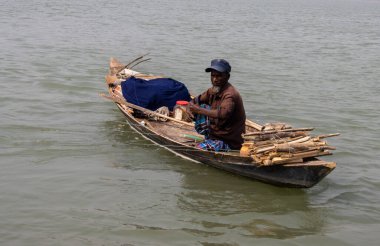 Barisal, Bangladeş - 12 Mart 2023, Nehirde yüzen küçük bir sandalda balık yakalayan bir balıkçı. Güzel Güneydoğu Asyalı balıkçı günlük hayatı. Yaşlı balıkçı bir tekneyle nehirde balık tutuyor..