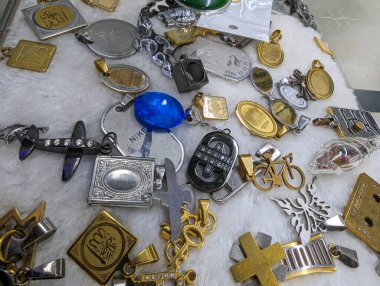 Güneydoğu Asya pazarında renkli ve şık erkek mücevherleri. Erkek anahtarlıklar ve madalyonlar markette yakın çekim. Gösterişli anahtarlıklar ve madalyonlar. Erkekler için gümüş ve altın mücevher. Erkekler giyer.