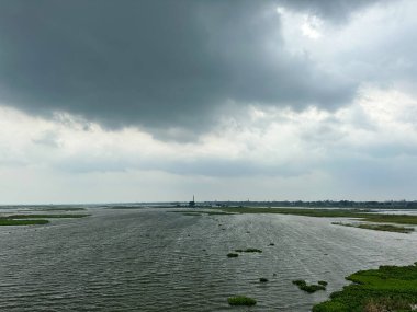 Güzel bulutlu gökyüzü ve nehir manzarası. Yağmur mevsiminde yoğun kara bulutlarla manzaralı nehir manzarası. Alacakaranlık zamanı gökyüzü manzarası kara bulutlar ve bulutlu gökyüzü. Güneydoğu Asya su yolu manzarası.