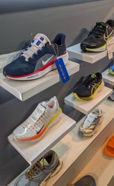 Alışveriş ortamında spor meraklıları için çeşitli stil ve renklerin sergilendiği bir perakende mağazasında modern spor ayakkabıları sergileniyor, Dhaka - Bangladeş - Aralık-04-2024