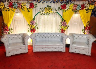 Unutulmaz bir olay için lüks mobilyalar ve canlı renkler sergilenen bir mekanda çiçeklerle süslü şık oturma düzenleri.