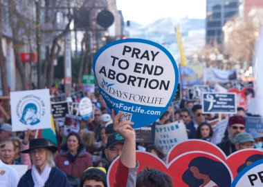 San Francisco, CA - Jan 21, 2023: Unidentified participants in the annual March for Life, holding pro-life signs and banners, walking down Market street towards the Embarcadero