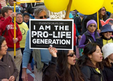 San Francisco, CA - Jan 21, 2023: Unidentified participants in the annual March for Life, holding pro-life signs and banners, walking down Market street towards the Embarcadero