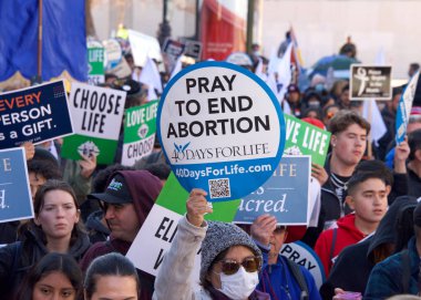 San Francisco, CA - Jan 21, 2023: Unidentified participants in the annual March for Life, holding pro-life signs and banners, walking down Market street towards the Embarcadero